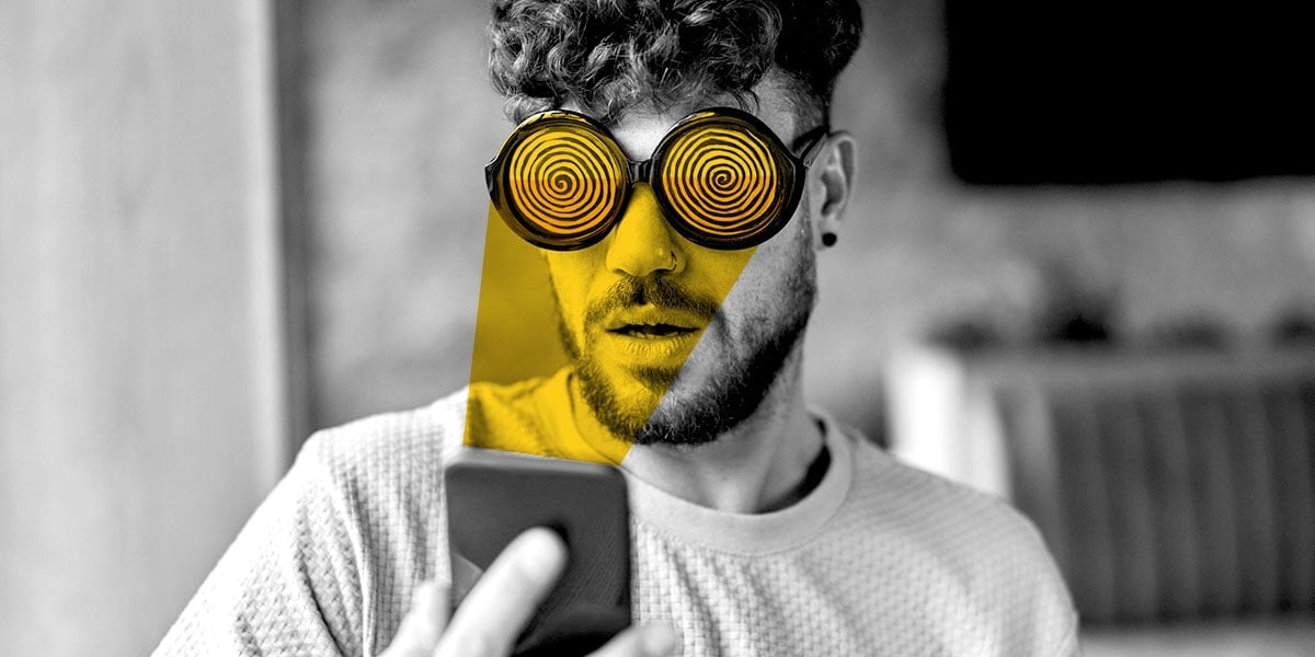 A man wearing hypnosis gimmick glasses stares at his phone screen, a victim of ad fatigue