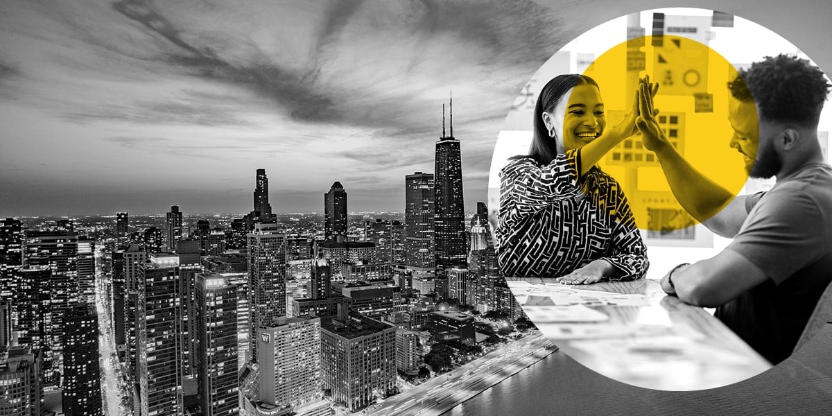 A female marketer and her client high-five against the backdrop of the Chicago skyline