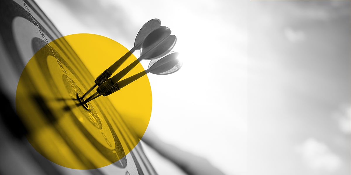 Close-up of three darts hitting the bullseye on a target, symbolizing precision in marketing analytics. 